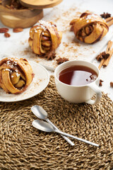 Fresh vegan cinnamon buns on marble board and white marble table