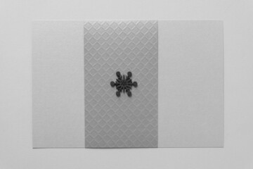 isolated dark gray snowflake (or star) on textured silver-gray paper