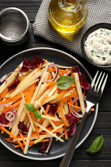 Fresh turnip salad served on dark wooden table, flat lay