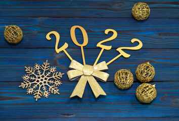 2022 new year, golden numbers on a blue wooden background, gold ribbon bow, Christmas background, new year wallpaper.
