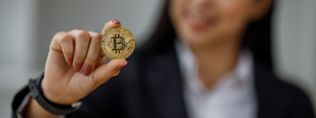 Golden Bitcoin token coin in a Woman hand, Digital symbol of a new virtual currency