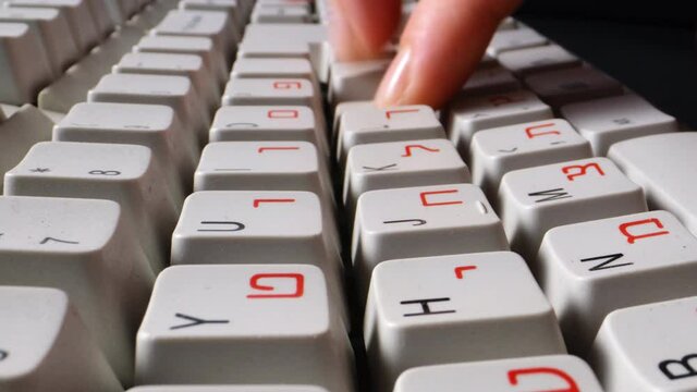 fingers typing text on a computer keyboard with English and Hebrew alphabet. High quality 4k footage