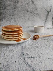 pancakes with honey on a gray background