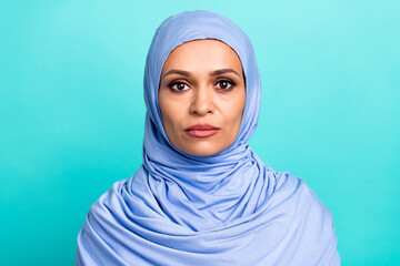 Photo of serious confident young lady dressed islamic hijab isolated teal color background