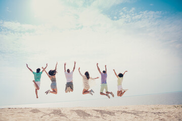 Rear back view photo of positive funny carefree group jump raise arms wear casual outfit nature...