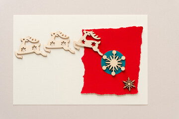 wooden christmas decorations (reindeers and snowflakes) on paper