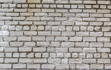 Old brick wall. Bricks gray. Cracks, weathering.
