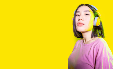 Confident asiatic woman indoors wearing wireless headphones looking camera confident and attitude...