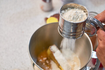 Woman prepares cookies in the kitchen, flouring the recipe.