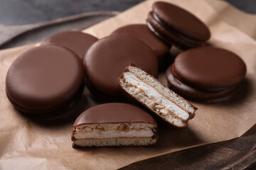 Tasty choco pies on parchment paper, closeup view