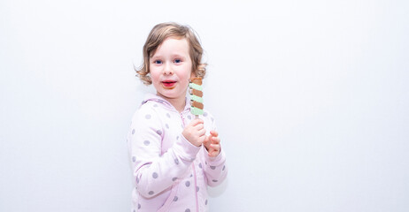 Caucasian girl eats frozen juice, ice cream and is very happy. Copy space.