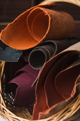 Rolls of genuine brown leather in a basket. Materials for leather goods. Manufacture of leather goods.