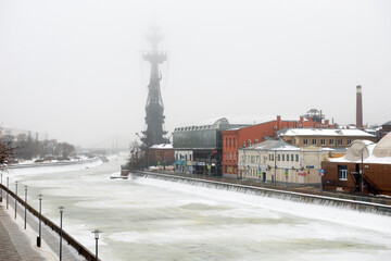 View on the Bolotnaya Embankment, Drainage channel and the bronze monument to Peter the great on the Moscow river on a foggy winter morning. Misty winter morning in Moscow.