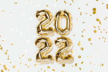 New year 2022 balloon celebration card. Gold foil helium balloon number 2022, party decoration, gold confetti stars on white background. Flat lay, merry christmas, happy holidays concept.