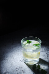 A glass with mineral water with lemon and mint