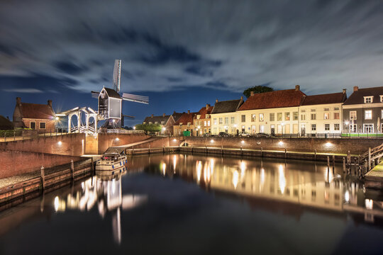 Historical harbor with windmill, drawbridge and mansions at night, Heusden, The Netherlands