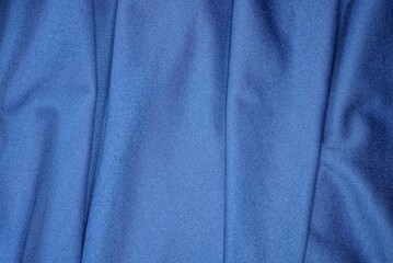 Blue synthetics fabric background of a fragment of crumpled cloth from clothes