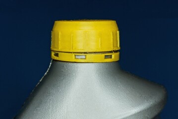 a piece of gray plastic bottle closed with a yellow stopper with lube