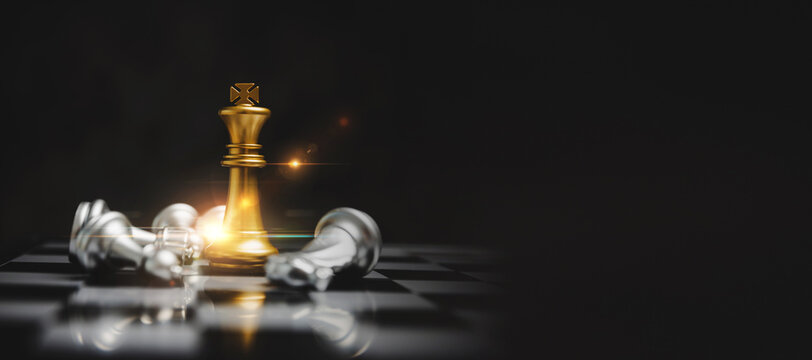 Wide banner. golden king with silver chess piece on chess board game competition with copy space on dark background, chess battle, victory, success, team leader, teamwork, business strategy concept