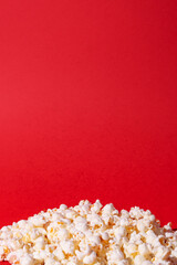 A bunch of popcorn on a red background. Text space. Holidays, cinema time concept. Minimal style.