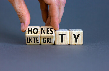 Honesty and integrity symbol. Businessman turns wooden cubes and changes the word integrity to...