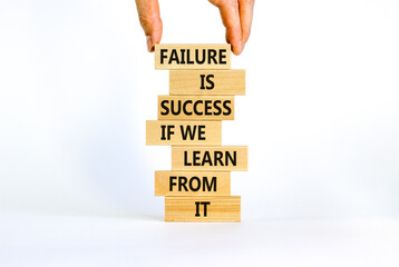 Failure or success symbol. Wooden blocks with words Failure is success if we learn from it. Beautiful white background, copy space. Businessman hand. Business, learn from failure or success concept.