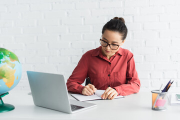 young teacher in eyeglasses working from home.