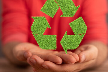 hand holding green recycle symbol