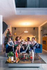 A happy family is sitting in a Christmas decorated living room