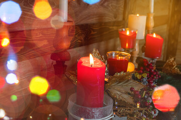 Festive Christmas Mantel shelf, decoration for the New Year. Spruce twigs, golden berries, balls, big red candles, garlands