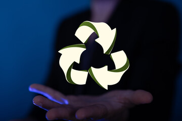 hand holding green recycle symbol