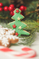 Christmas decoration. Christmas tree branches and homemade decorated Christmas cookies, close up image.