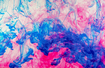 Texture created with blue and magenta watercolor paint flowing in the water mix as it falls