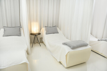 Beautiful luxurious white interior of a massage room with two beds for two people to relax and in a modern wellness spa