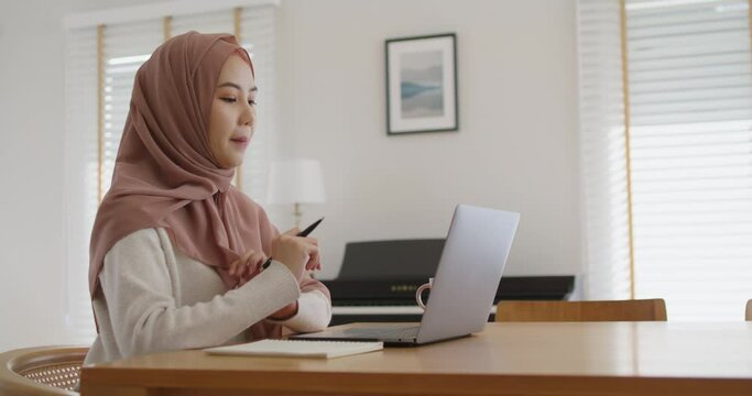Asia arab people young woman wear hijab headscarf plan study MBA college class note idea data in sale report remote work at home on laptop. Happy advisor lifestyle smile cowork smart workforce job.