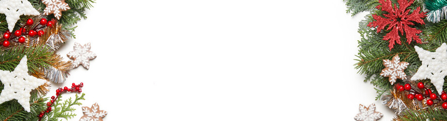 Christmas decoration. Christmas tree branches, red berries and snow flake shaped cookies on white background.