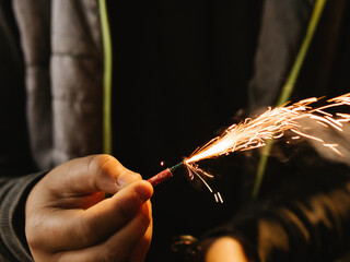 teenager's hands lighting a firecracker - obrazy, fototapety, plakaty