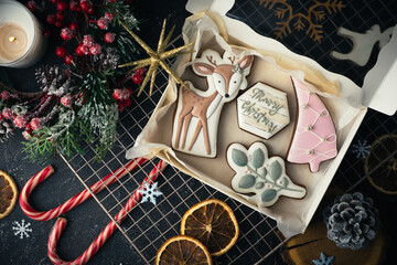 Flat lay of Christmas gingerbread cookies with festive icing and Christmas decoration on the black background. Merry Christmas and Happy New Year