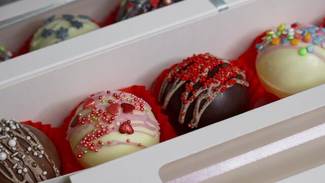 Delicious, beautifully decorated candies in a box. Sweet gift for a holiday. Close-up.