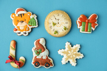 Flat lay of Christmas gingerbread cookies with festive icing on the blue background. Year of a tiger