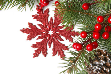 Christmas decoration. Red Christmas ornament with fir branches and red berries. Festive winter holidays concept.
