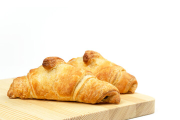 Delicious, crunchy croissant with filling on an isolated white background. Breakfast bakery on a wood cutting board. Healthy eating. European breakfast