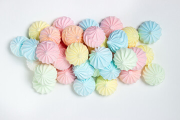 Multicolored meringues on a white background. Light and tasty dessert.
