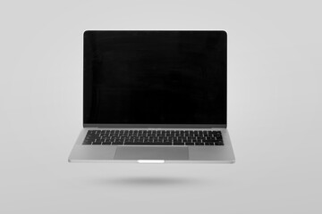 Laptop computer with empty screen levitating in the air on a gray background. Creative minimal...
