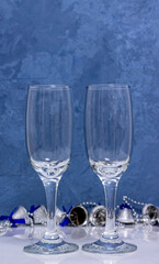 Two empty glasses for champagne on a blue background close-up. New Year Christmas.