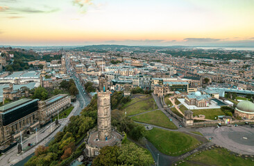 Aerial sunrise view of Calton Hill in Edinburgh, Scotland surrounded by old buildings. Locals use the hill to observe the vastness of the city, enjoy festivals, or attend to spiritual activities