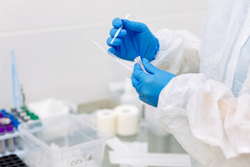 Fototapeta premium scientist working in laboratory in blue medical gloves doing a covid test 