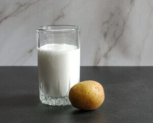 Vegan potato milk. Diet milk made from vegetables. A glass of milk and chopped potatoes. High...