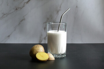 Vegan potato milk. Diet milk made from vegetables. A glass of milk and chopped potatoes. High quality photo