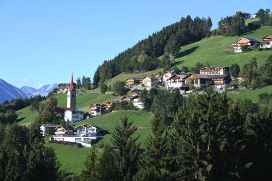 Das Bergdorf St. Leonhard bei Brixen in der Province Bozen in Südtirol, Italien. In der Ortsmitte steht die St. Leonhardskirche. Sie wurde 1194 eingeweiht um 1430 neu gestaltet und später barockisiert